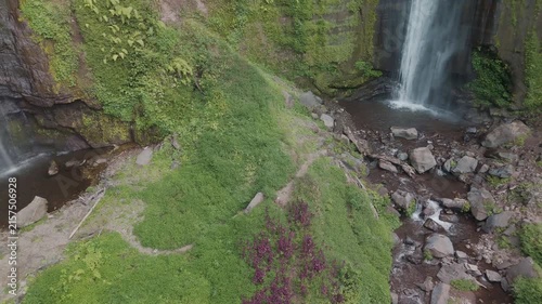 Vibrant Green Landscapes with a Cascading Waterfall Surrounded by Lush Vegetation and Rocks