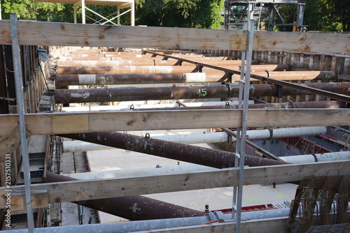 Deep excavation with steel pipes and bracing at Zurich construction site.