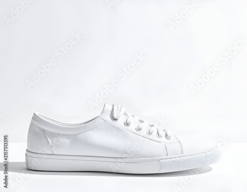 Side profile of white canvas lace-up sneaker.