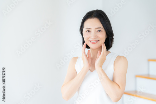 リビングでスキンケアをするミドルの女性