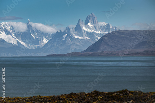 Fotografie Jagged snowcapped mountains rise beyond a calm Patagonian lake.