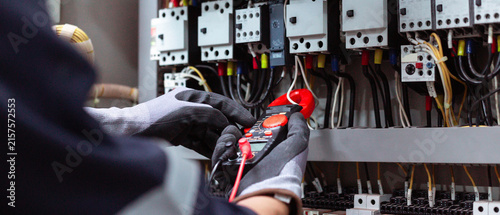 Fotografía Electrician using digital clamp meter to measure electrical current in control panel