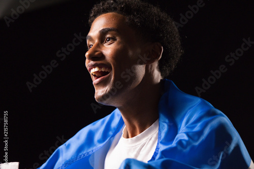 Fotografie African man smiling and looking upward-left in studio wearing blue draped cloth
