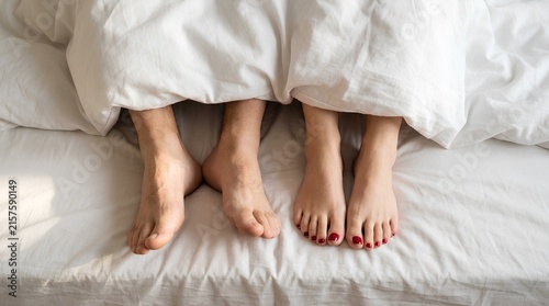 Couple Feet Peeking Out From White Blanket on Bed Overhead View Cozy Morning Relationship Concept