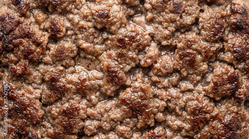 Coarsely comminuted beef protein matrix with irregular browned crust and visible compact meat granules