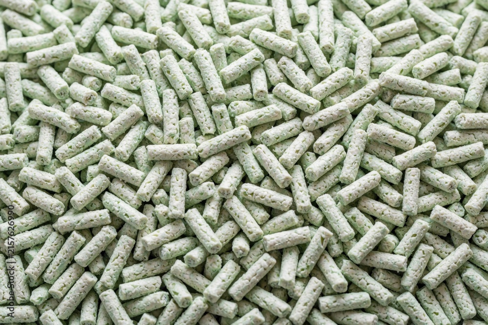 Fototapeta premium Close-up of light green tofu cat trash pellets filling the frame. These eco friendly pellets are made from soybeans forming small cylinders.