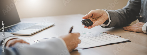 Foto close up shots hands of client signing car lease form.