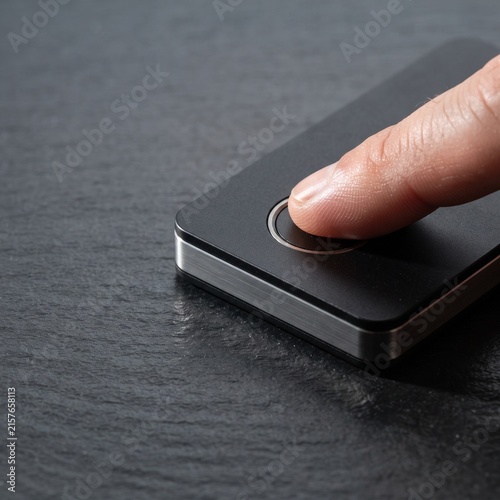 Biometric fingerprint scanner on black slate, person using finger touch sensor for secure access, modern identity verification technology