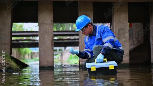 Water quality inspector collecting environmental samples from wastewater treatment infrastructure