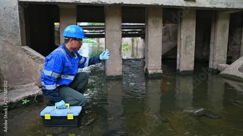 Environmental technician monitoring water quality and collecting samples from an industrial water system
