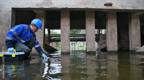 Environmental technician monitoring water quality and collecting samples from an industrial water system