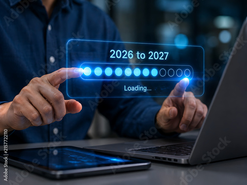 Man interacting with futuristic loading bar interface displaying 2026 to 2027 timeline on a laptop