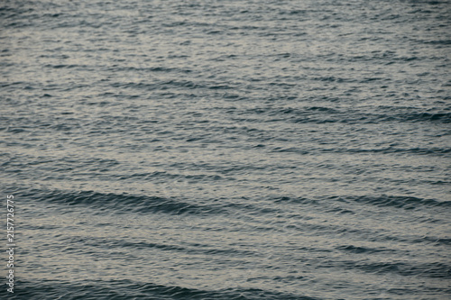 Konstfotografi Gentle waves caress the sandy shore under a dusky sky at twilight