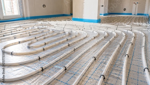 Underfloor heating pipes installed across an insulated floor in a new residential building, showing radiant heating, plumbing, construction and energy efficient home technology.