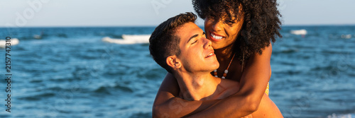 Konstfotografi Happy couple embracing by the ocean at sunset, expressing love, intimacy and summer romance