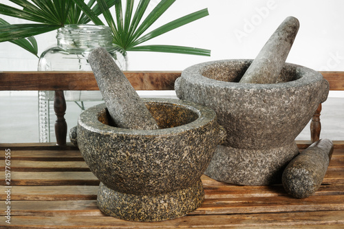 Foto Stone mortar placed on a wooden shelf