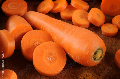 fresh raw carrot slices on wooden background