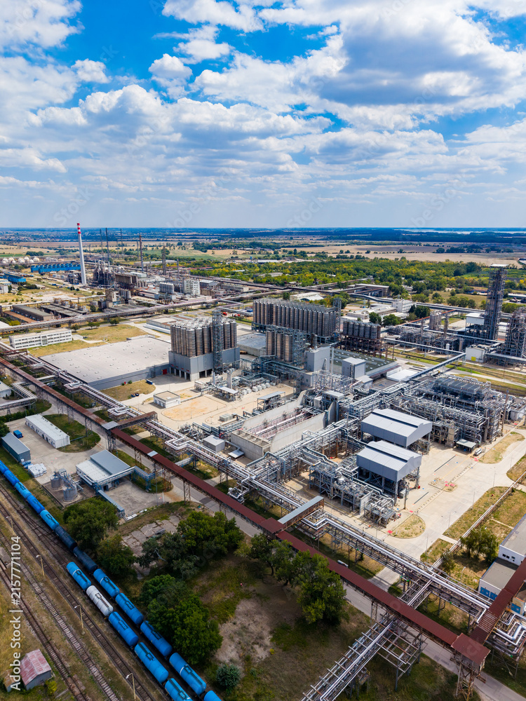 Fototapeta premium Industrial site with pipelines and processing units in a rural area during daylight
