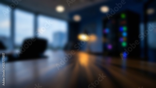 Blurred dark tech office interior featuring glowing servers and empty desk surface crafted as a corporate video call background or presentation backdrop