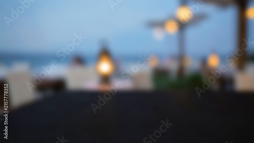 Blurred dark table surface with warm glowing bokeh lights at an oceanfront evening cafe for premium product display and menu presentation mockups