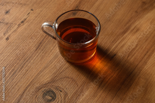 Принти на полотні A warm cup of tea resting on a wooden table in soft afternoon light, inviting re