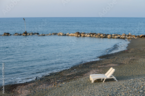 Fotografía Lone lounge chair by calm sea creates serene atmosphere at twilight on a peacefu