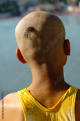 India. Uttarakhand. Rishikesh. A young man with a shaved head, retaining only a tuft of hair (choti/shikha) in accordance with Hindu tradition