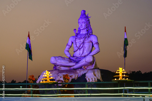 India. Uttarakhand. Rishikesh. A monumental statue of Shiva in meditation overlooks the Ganga Aarti, an evening ritual dedicated to the sacred river
