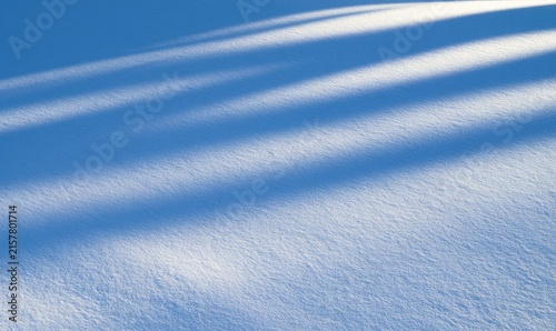 Diagonal shadows cast across pristine white snow