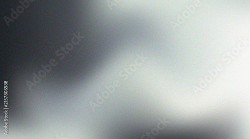 Abstract monochrome gradient background with soft blurred texture and grainy noise effect.