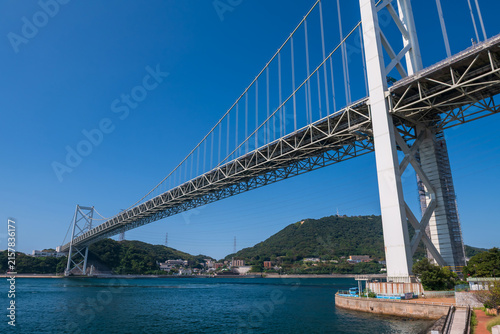 Iconic Kanmon Bridge by strait against blue sky, Kitakyushu, Fukuoka