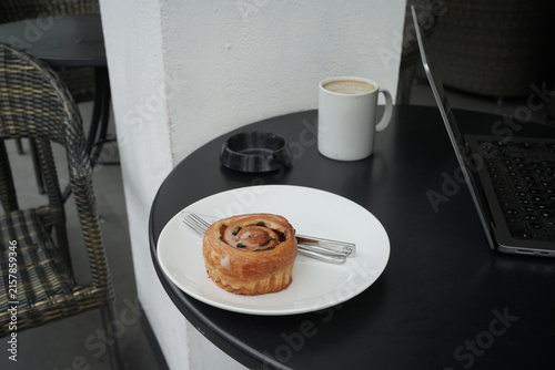 Fotografía Home bakery Danish pastry cake on dish and laptop on the table.