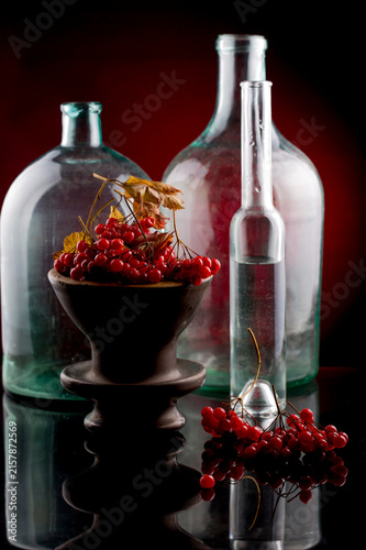 Still life with red viburnum berries and glass objects