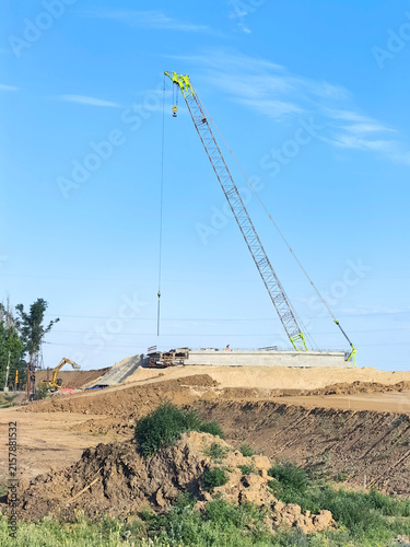 Foto Bridge and road interchange construction site with crane and earthworks on a clear day