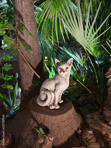Estatua de piedra de un gato en un jardín de noche