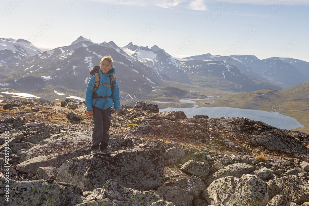 Obraz premium Beautiful european family with children and pet dog, hiking Kyrkja mountain on a beautiful sunny summer day, sunset, snow, lakes, valley
