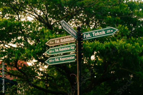 Campus directional sign among green trees