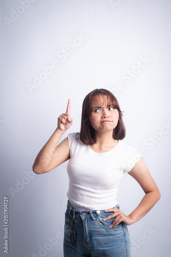 Young woman pointing up with thoughtful expression