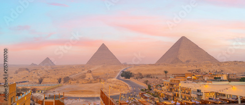 Panoramic view of ancient pyramids rising above a desert landscape at sunset in Cairo