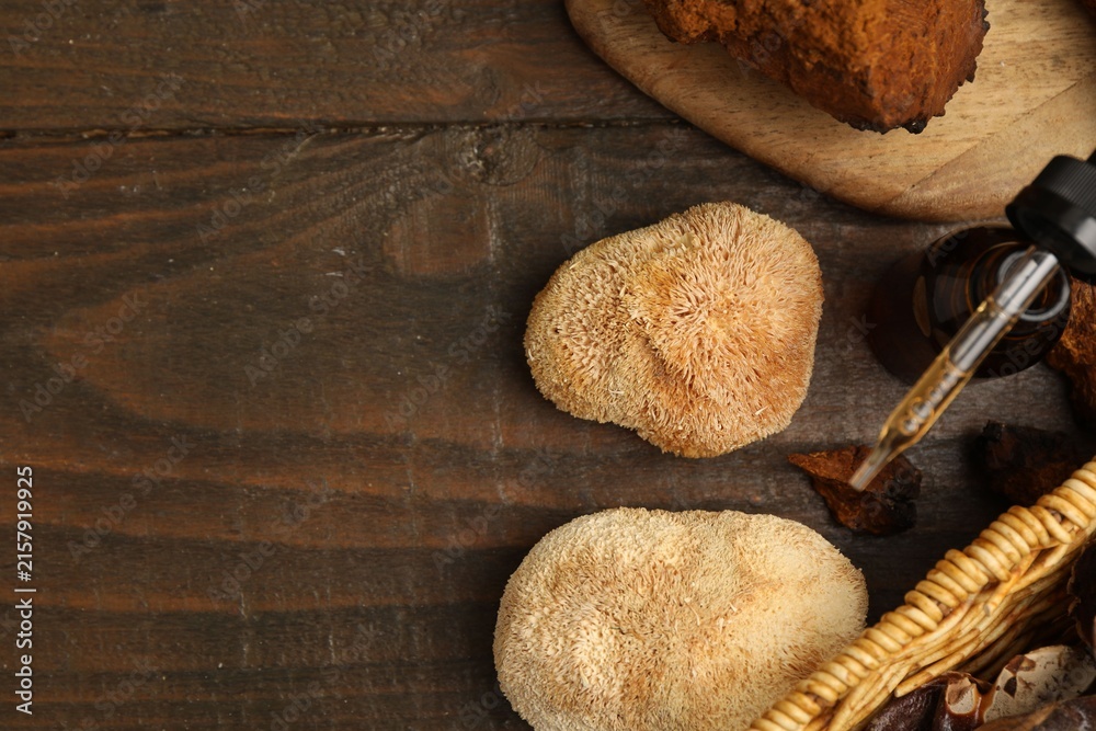 Fototapeta premium Functional mushrooms and bottle of oil on wooden table, flat lay. Space for text