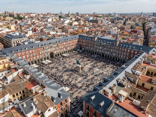 From above, Plaza Mayor is framed by historic structures and lively rooftops in Madrid, Spain