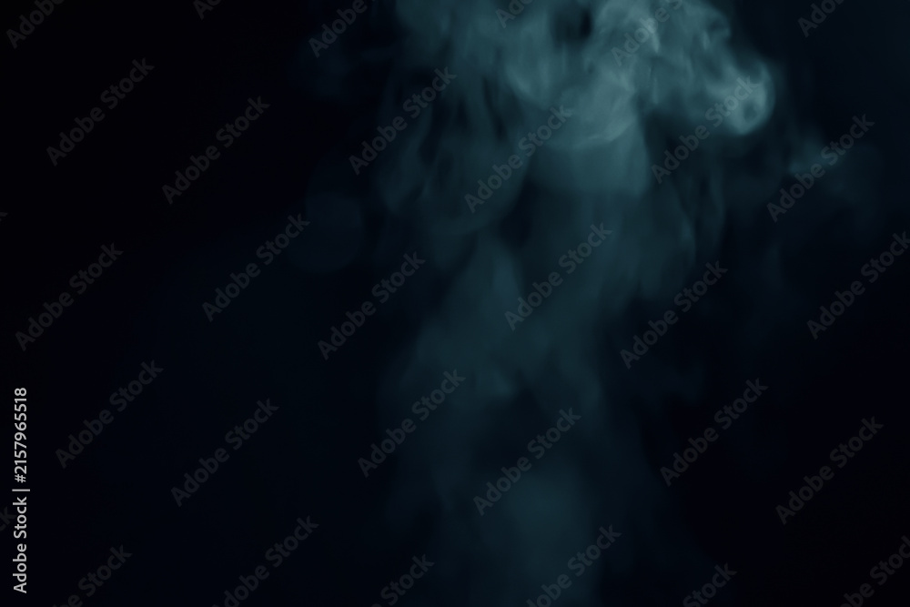 Fototapeta premium Abstract blue smoke vapor swirling against a dark black background