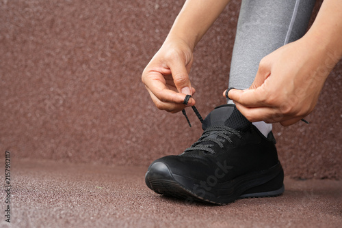 A woman ties her shoelaces ready to run at the gym.