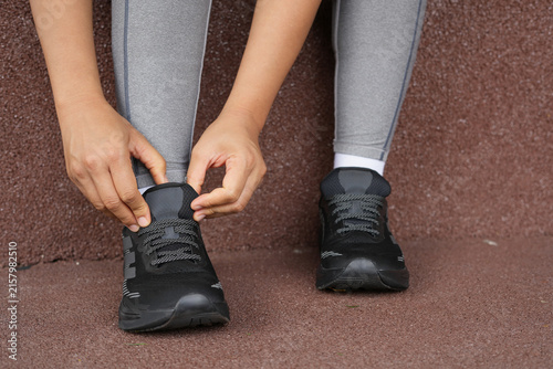 A woman ties her shoelaces ready to run at the gym.
