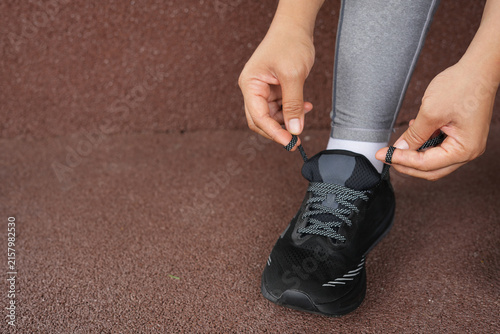 A woman ties her shoelaces ready to run at the gym.