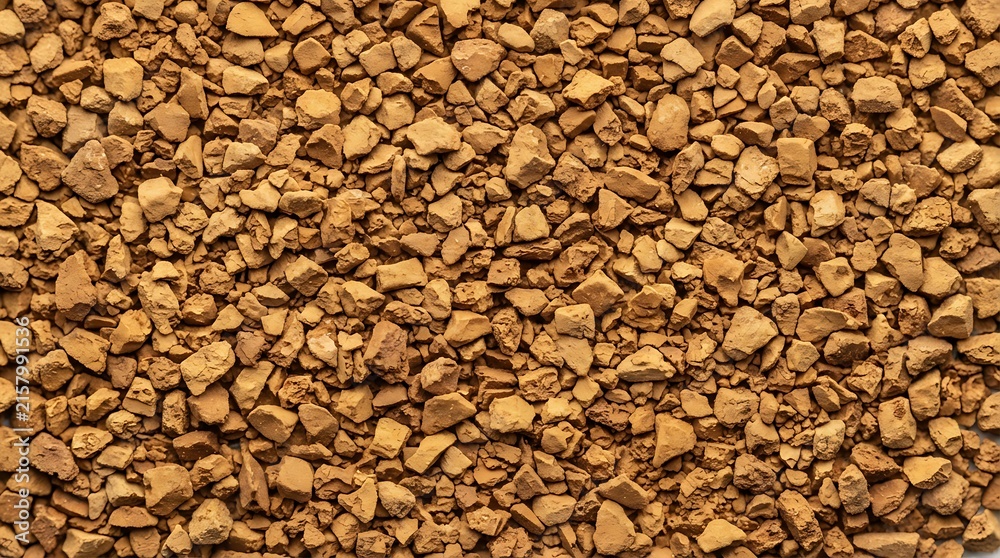 Naklejka premium Instant coffee granules close up view brown background texture.