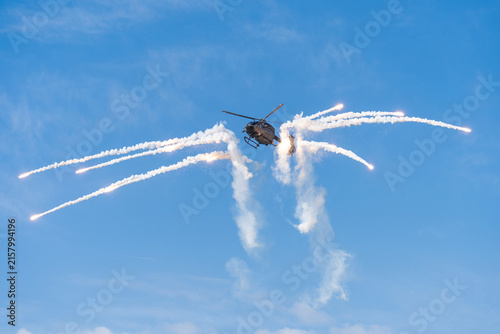 Black modern military transport helicopter shrouded in smoke over Budapest