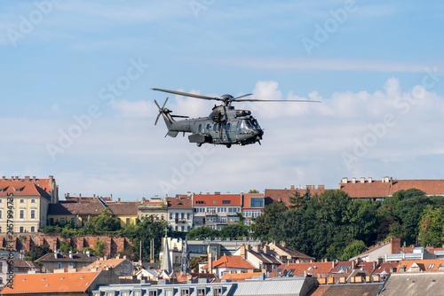 Black modern military transport helicopter flying over Budapest, Hungary