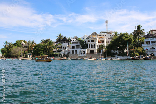 Obraz na płótnie Traditional dhow boats along the waterfront of Lamu Island, Kenya, with Swahili architecture and palm trees on the tropical Indian Ocean coast