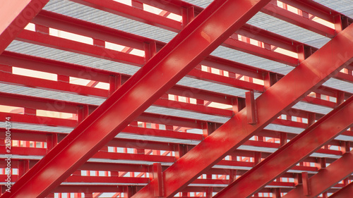 Red steel beams forming a geometric pattern against the sky